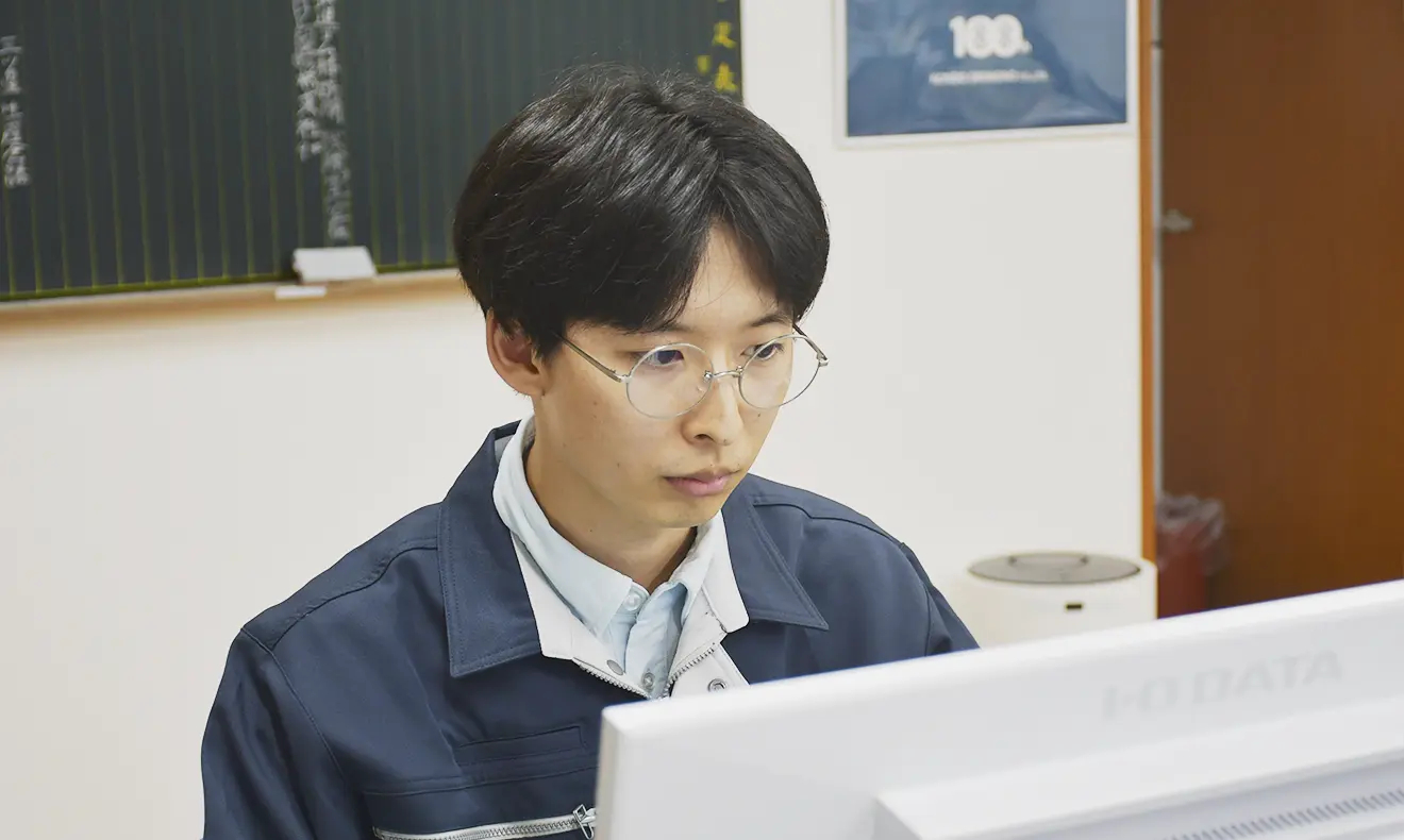 オフィスで業務に取り組む社員。落ち着いた雰囲気の中でパソコン作業に集中している。